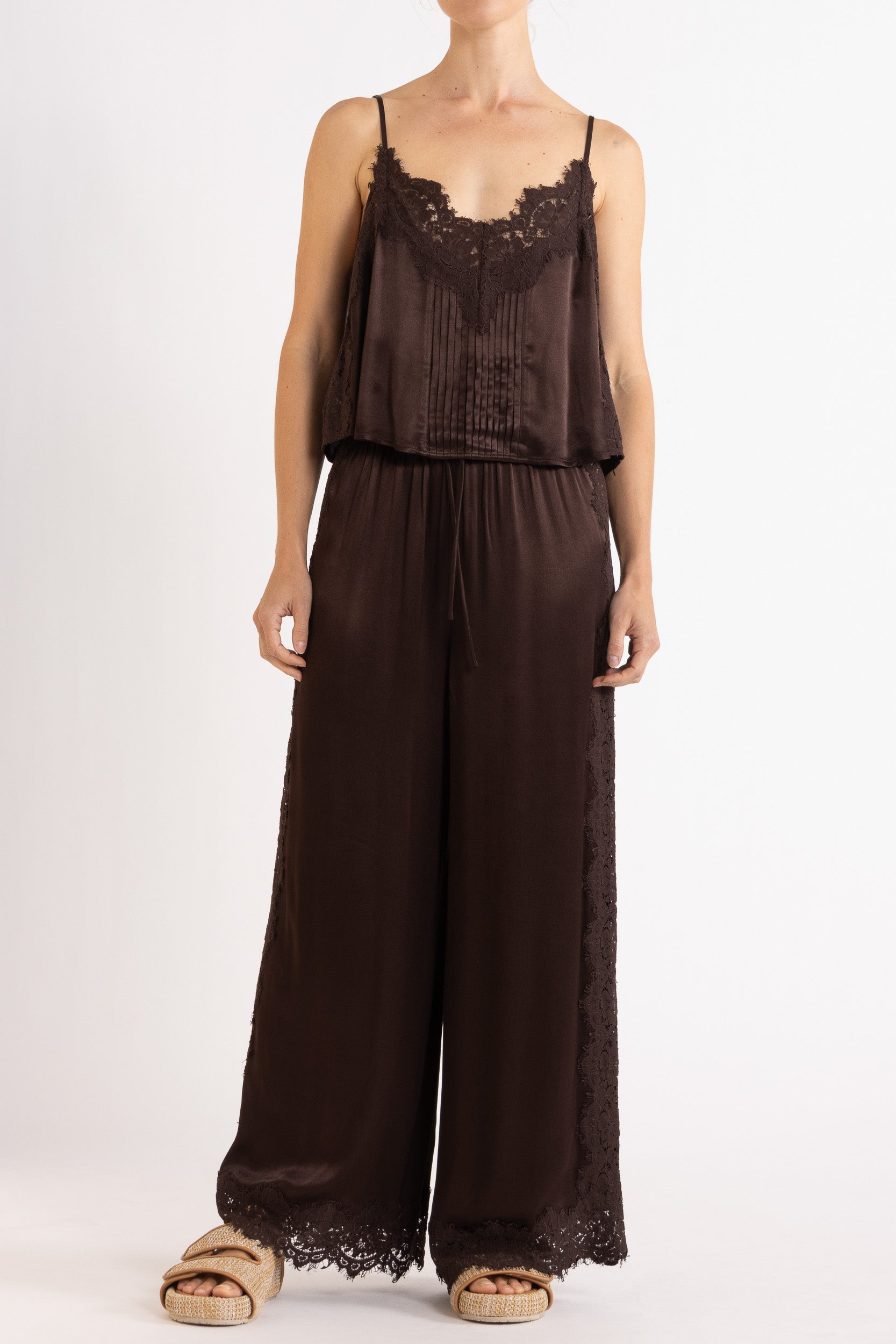 Woman wearing matching brown camisole and pant on a white background