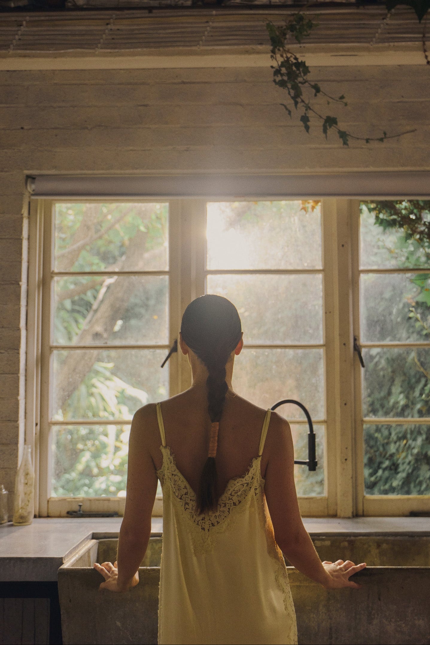 Model wearing vanilla lace and silk maxi dress with braided hair ad accessory. 