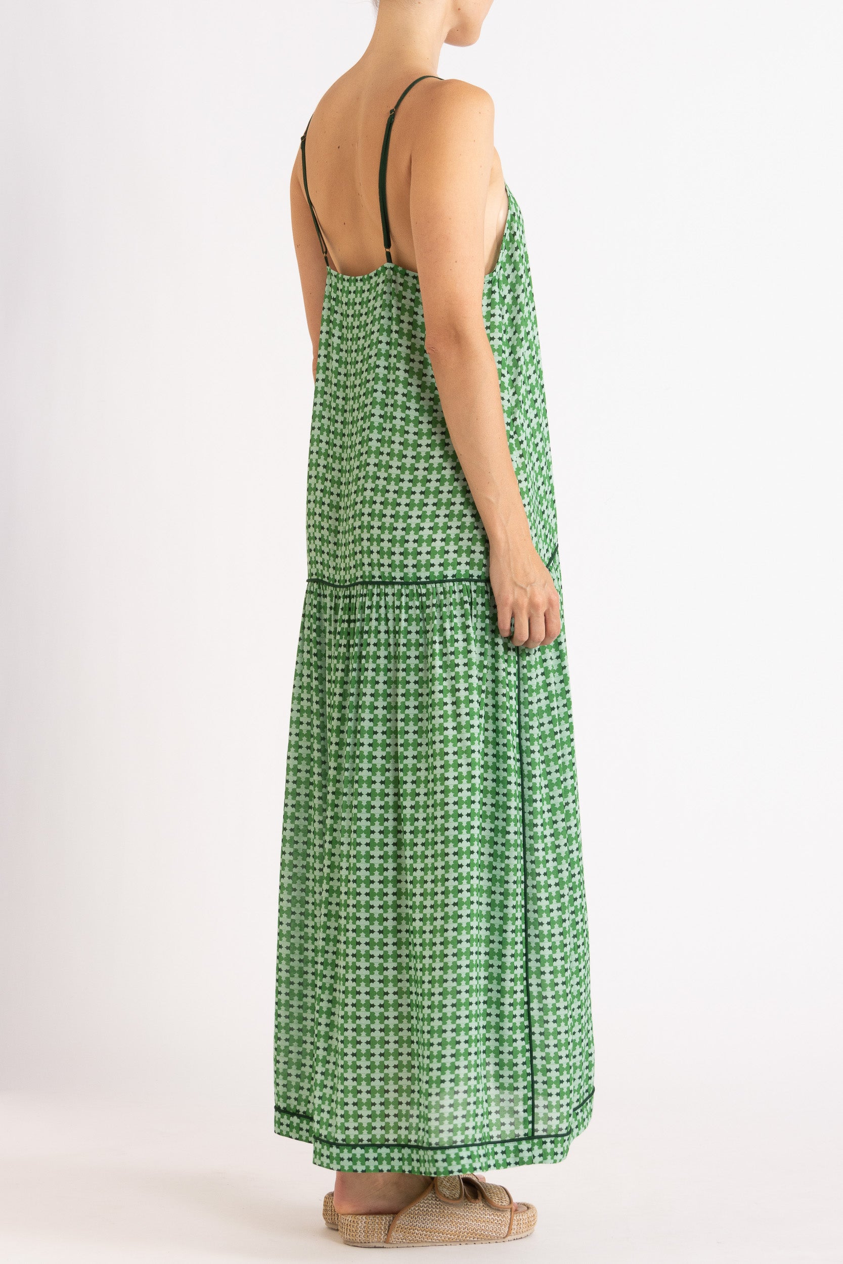 Model wearing green patterned dress, side-back view