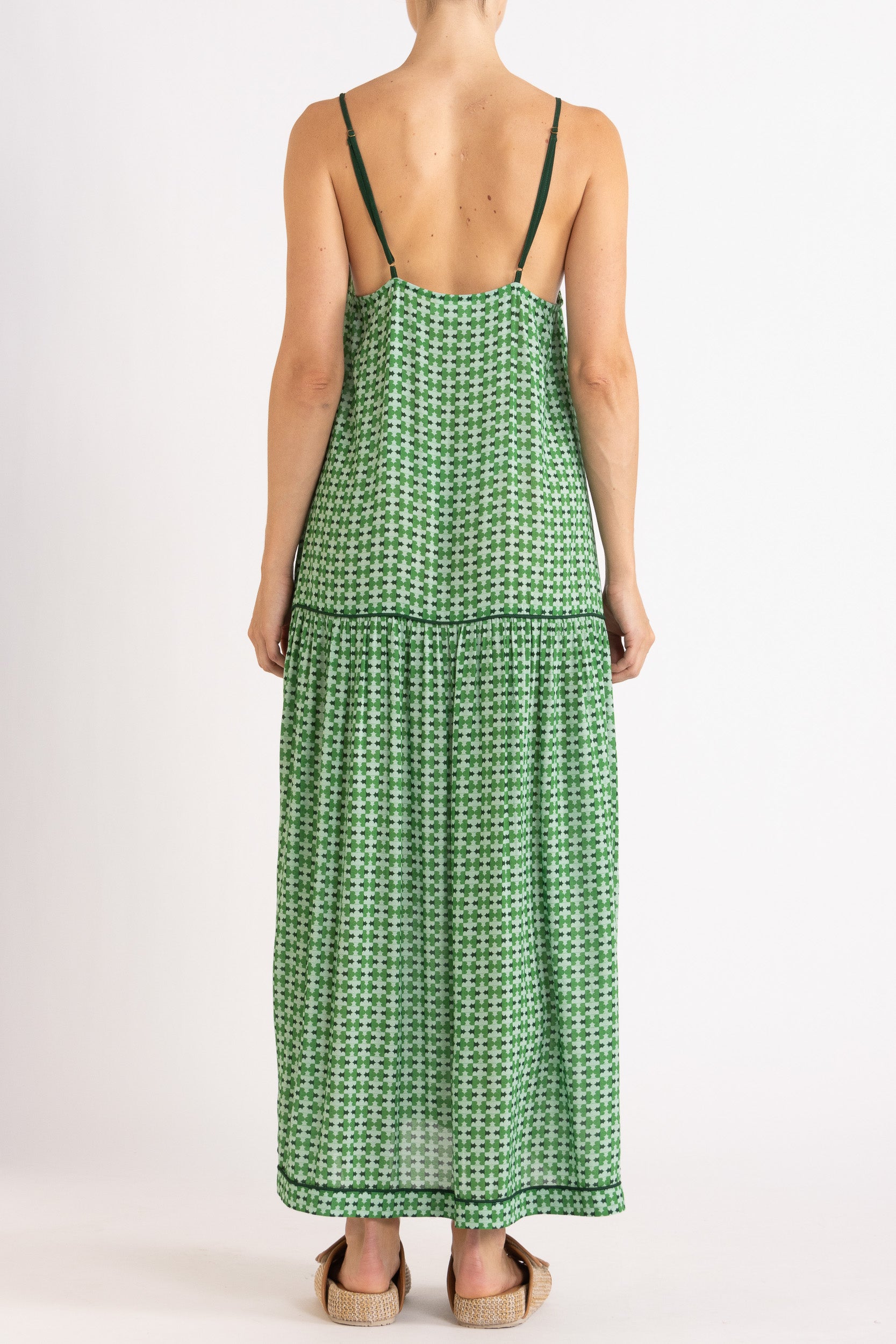 Model wearing green patterned dress, back view