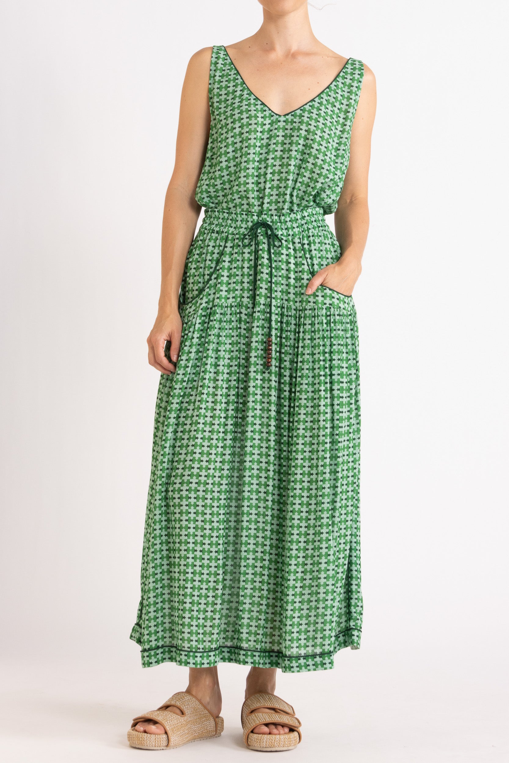 Model wearing green patterned tank top and skirt, front view