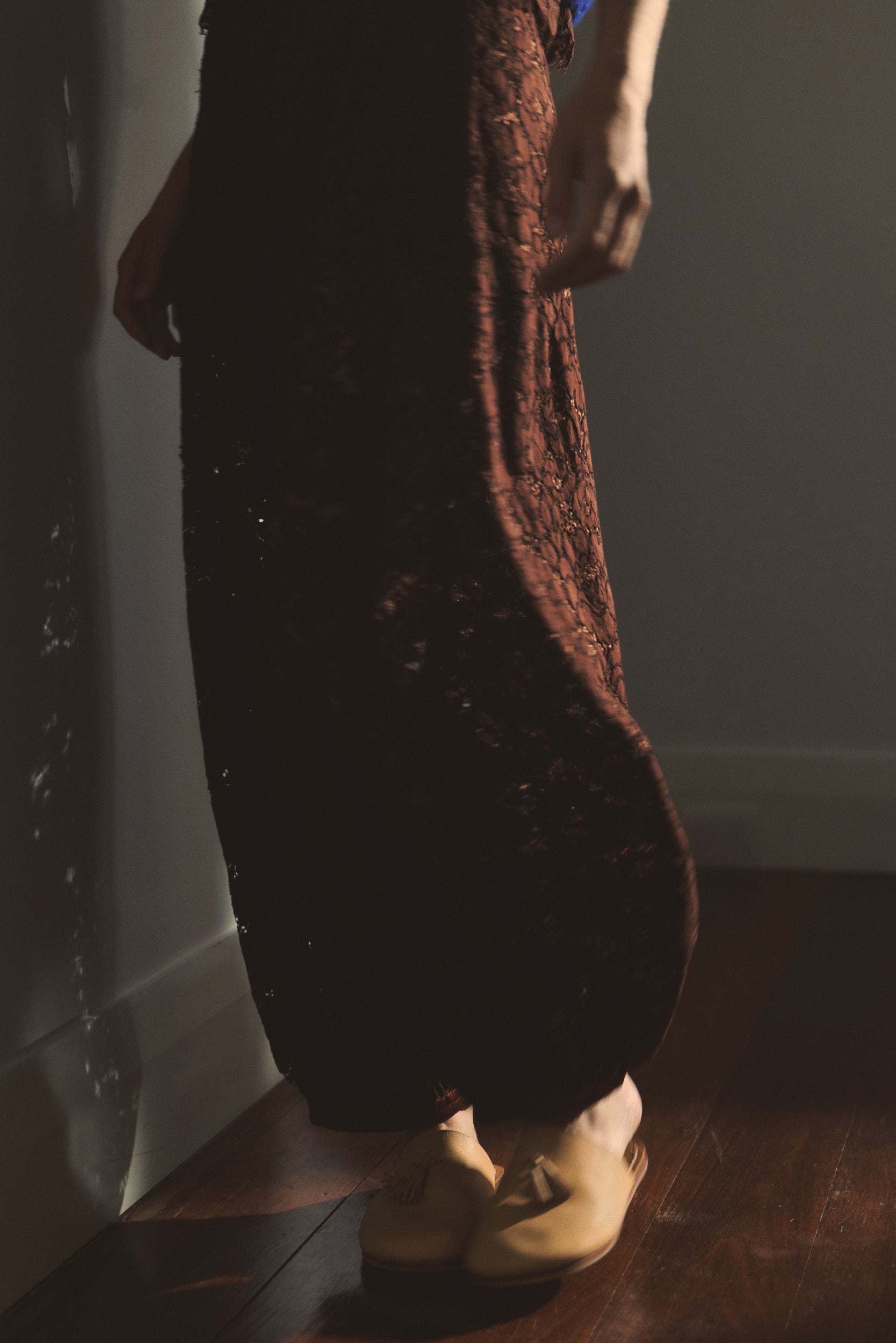 Close up image of model wearing brown lace pants. 