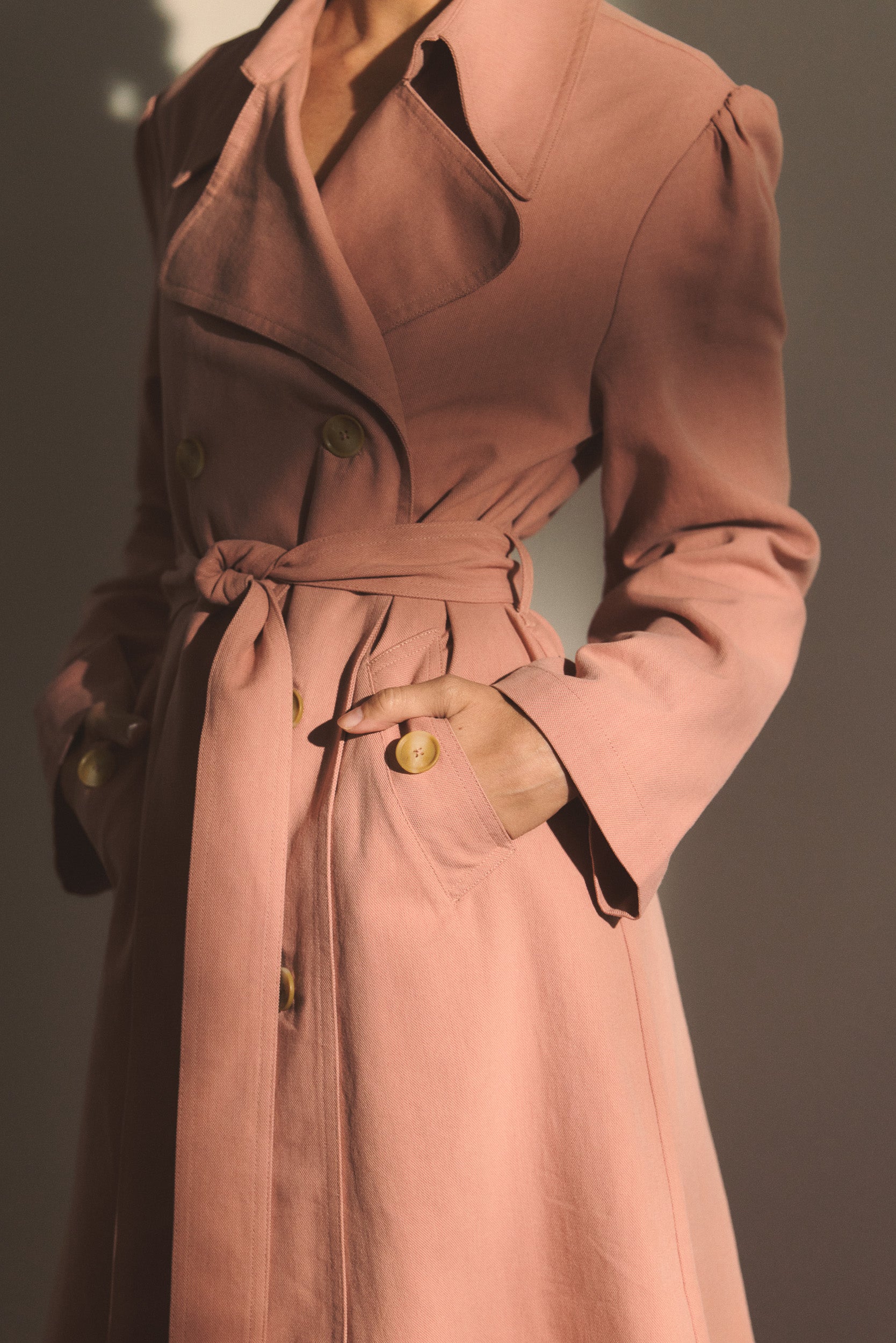 Model wearing a pink trench coat. 