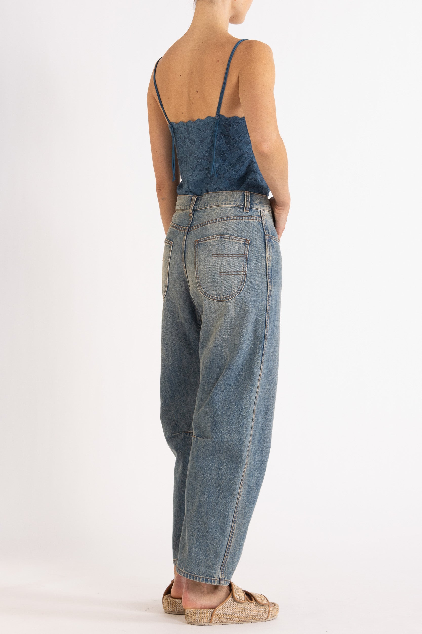 Woman wearing blue floral lace camisole with denim bow-leg jeans