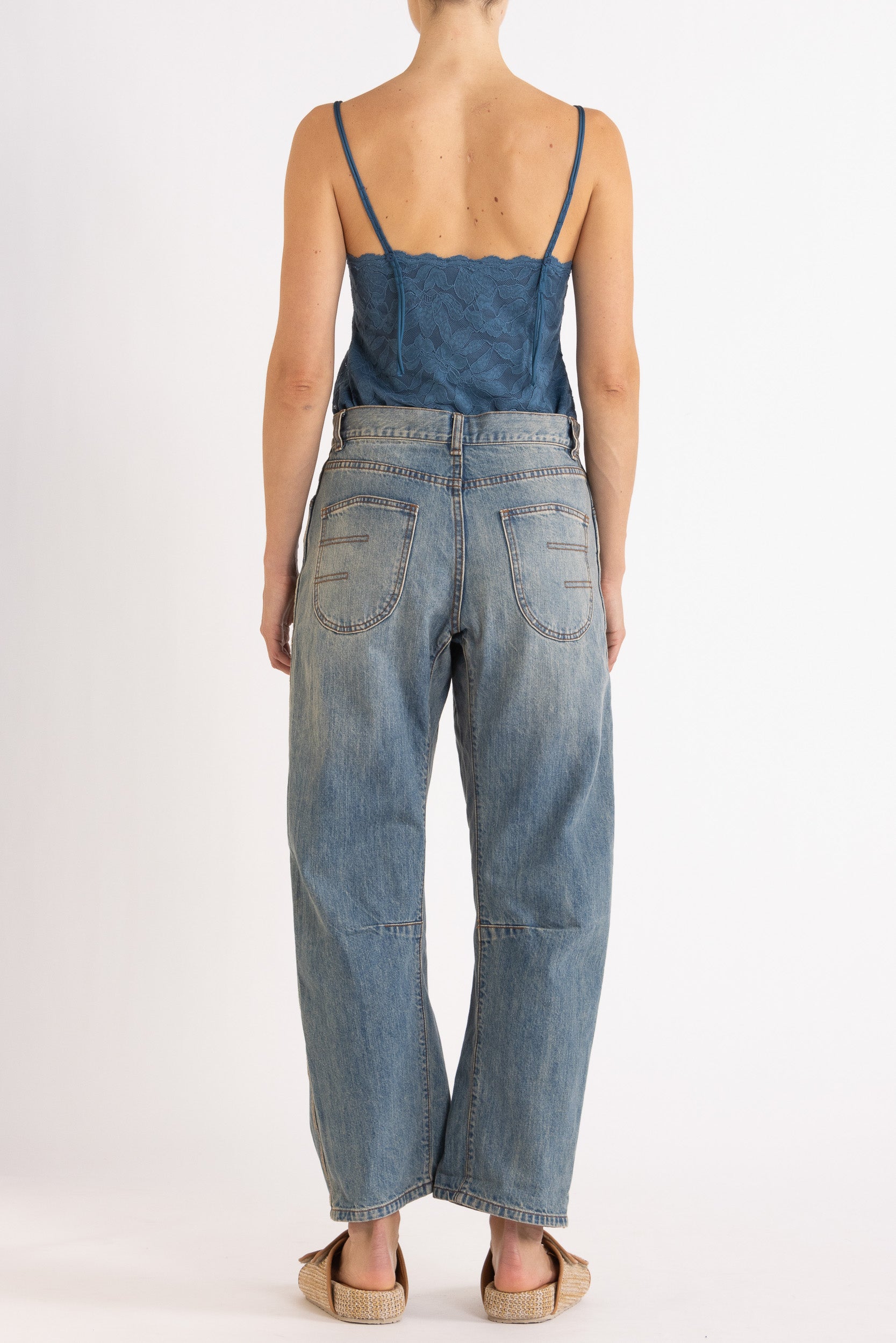 Woman wearing blue floral lace camisole with denim bow-leg jeans