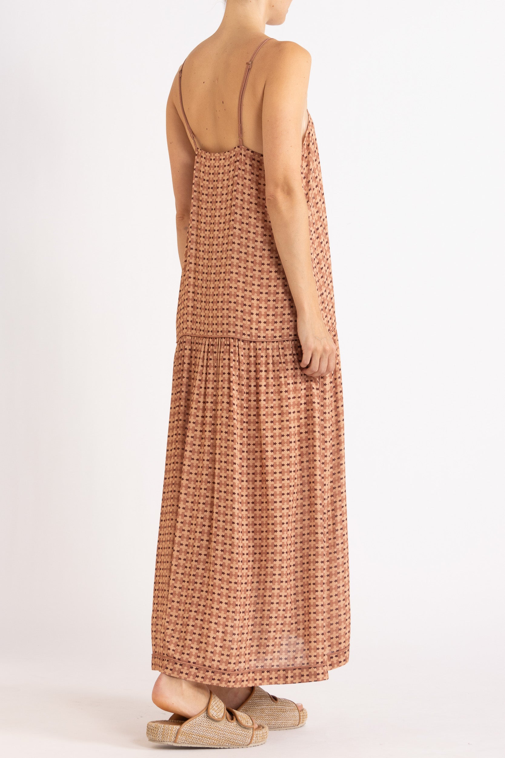 Model wearing peach patterned dress, back-side view