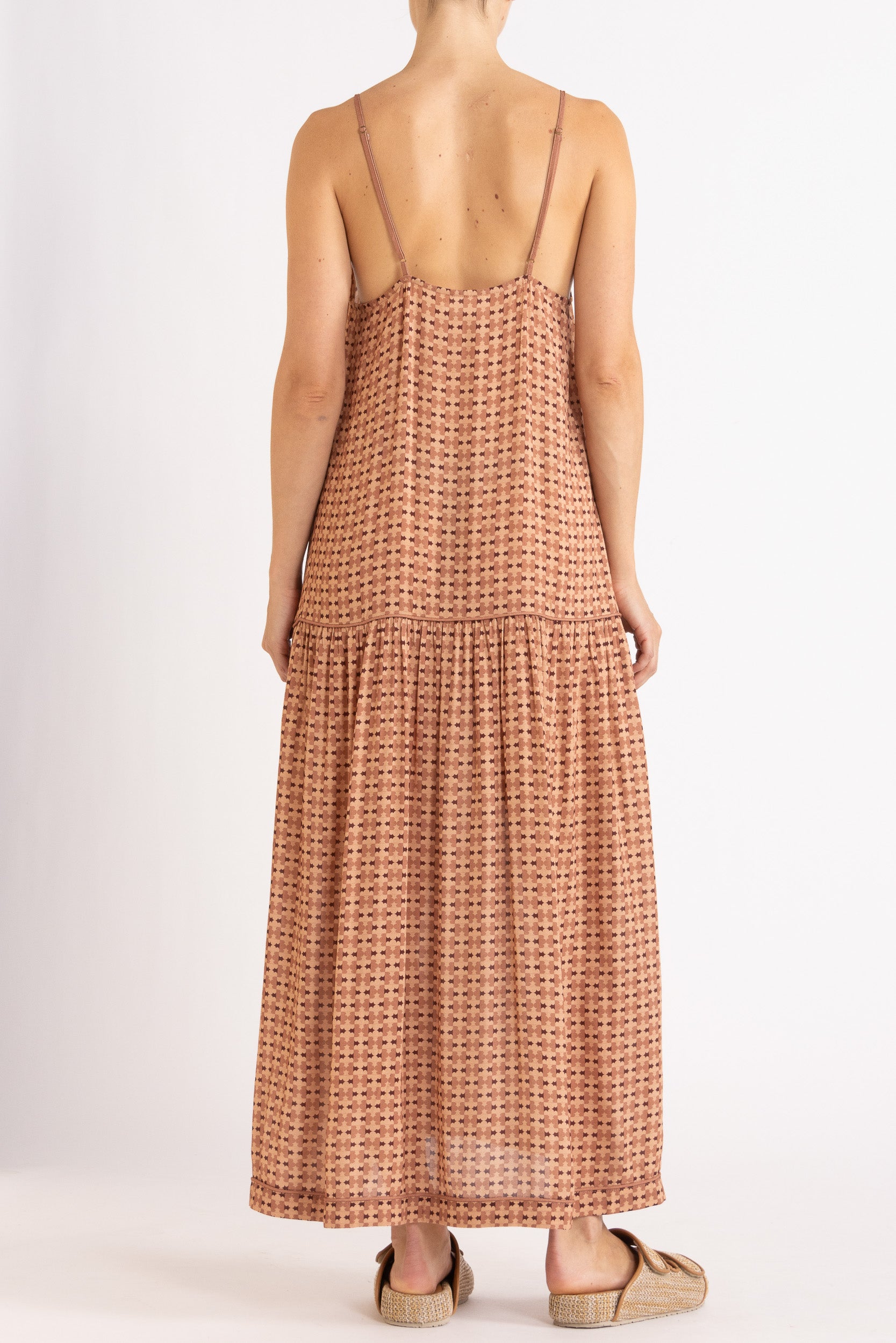 Model wearing peach patterned dress, back view