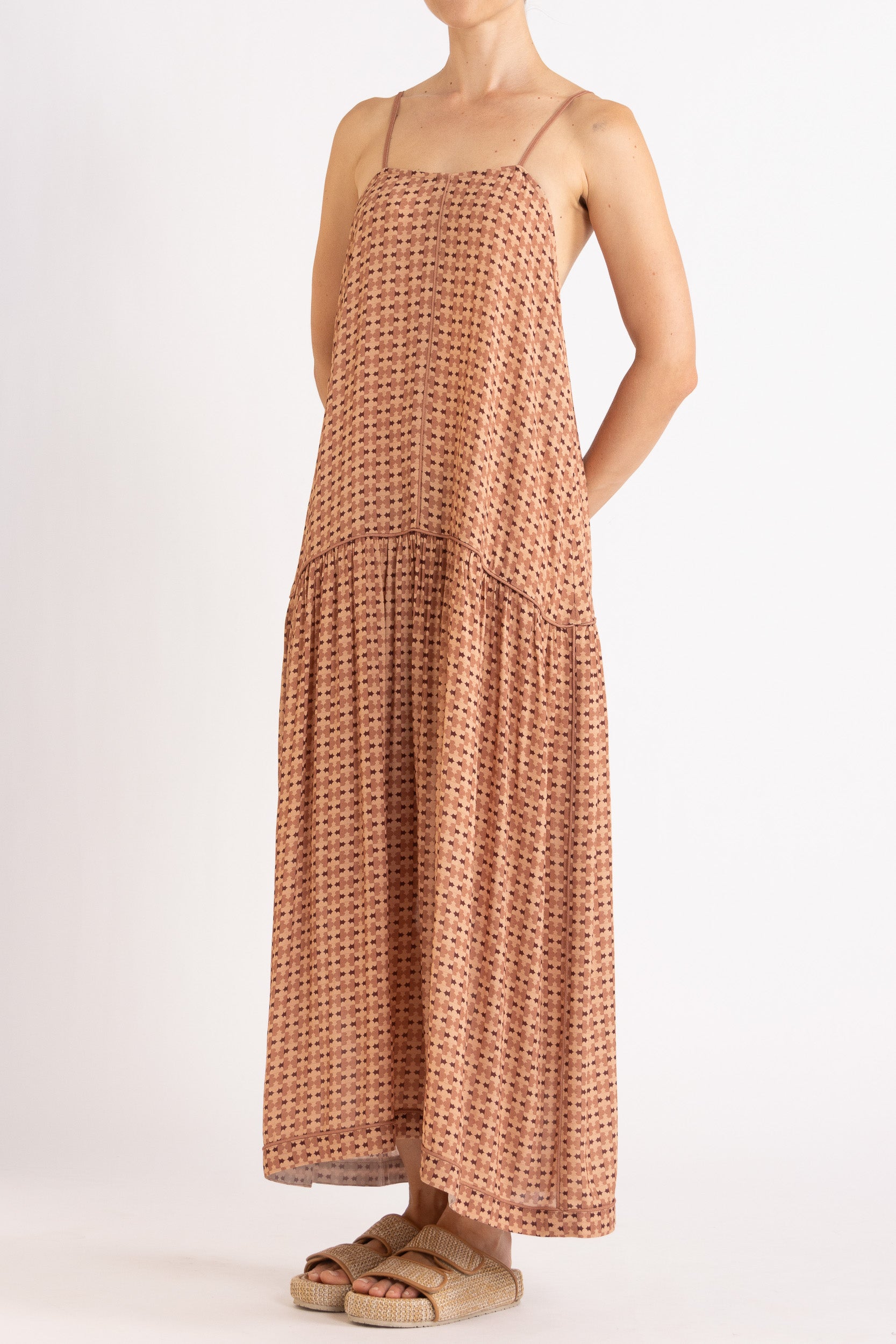 Model wearing peach patterned dress, front-side view