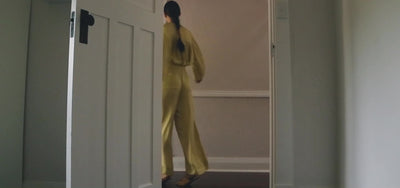 Video of female model wearing a lemongrass silk long sleeve top and pant. 