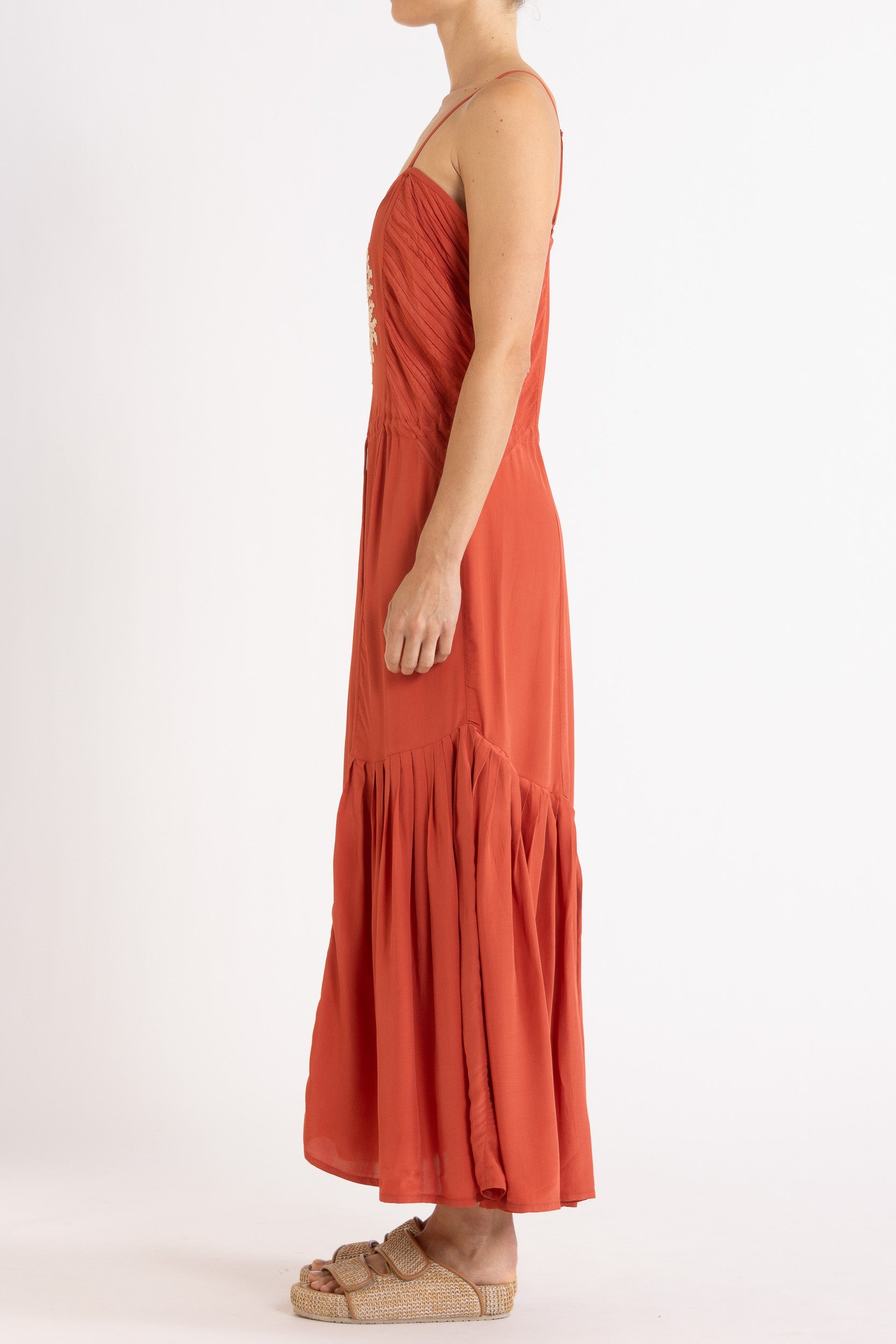 Woman wearing a red dress with floral embroidery on a white background