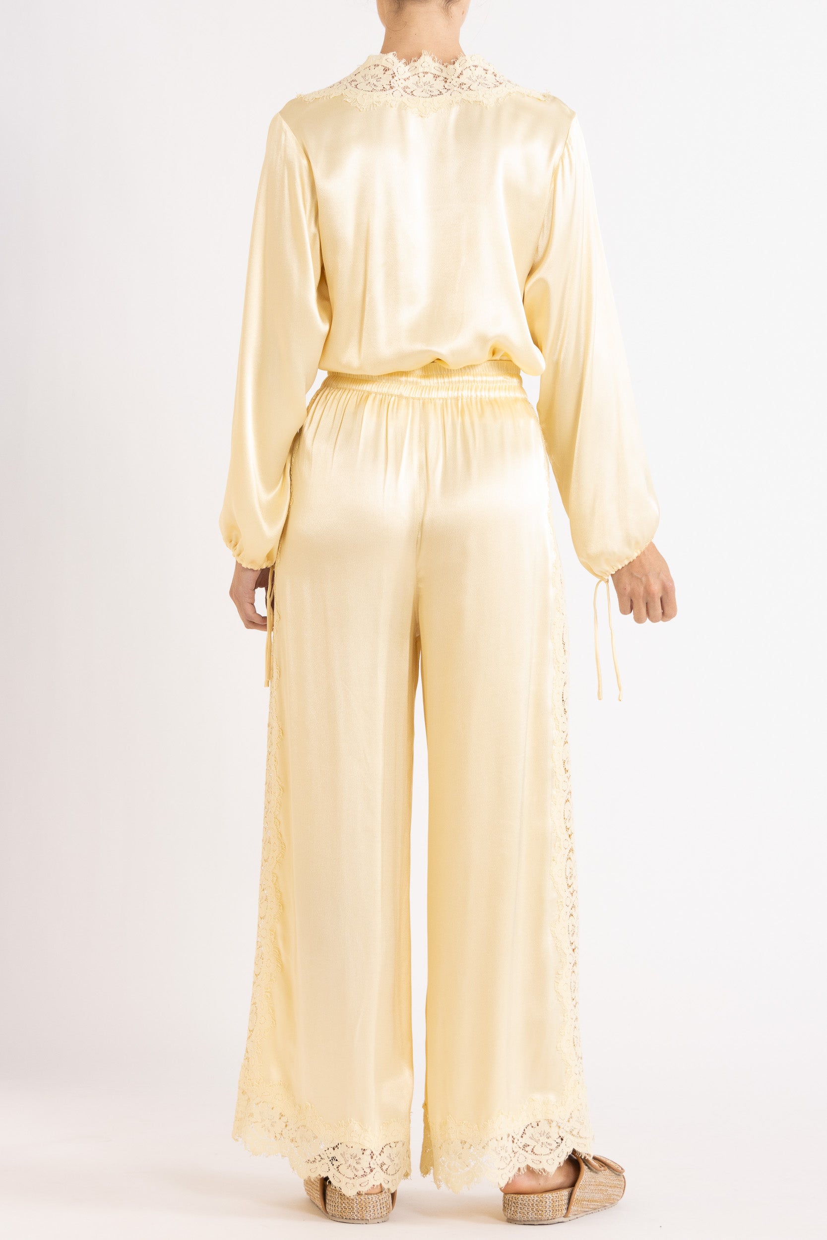 Woman wearing matching Vanilla lace-lined long sleeve top and pant on a white background