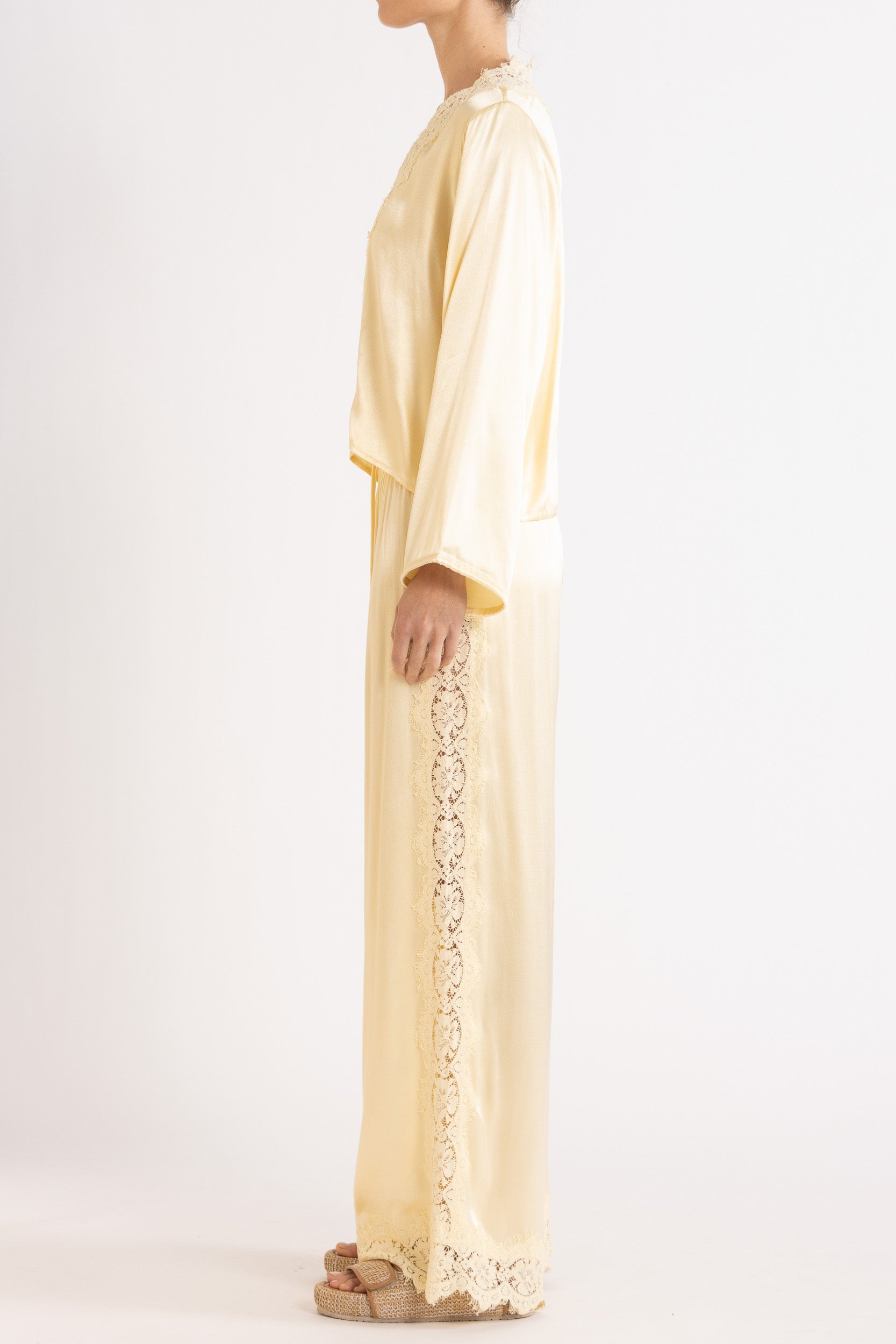 Woman wearing matching Vanilla lace-lined long sleeve top and pant on a white background