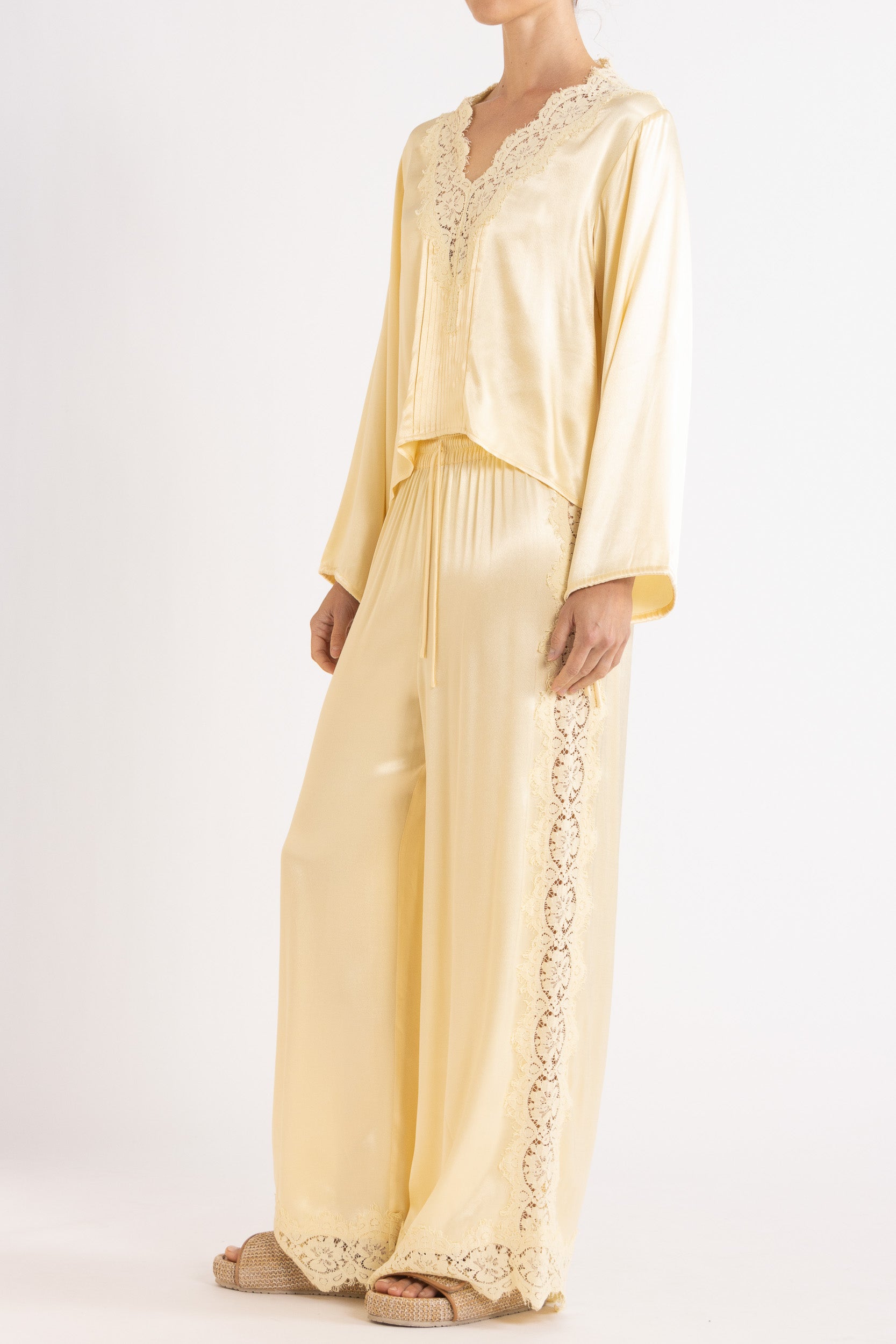 Woman wearing matching Vanilla lace-lined long sleeve top and pant on a white background