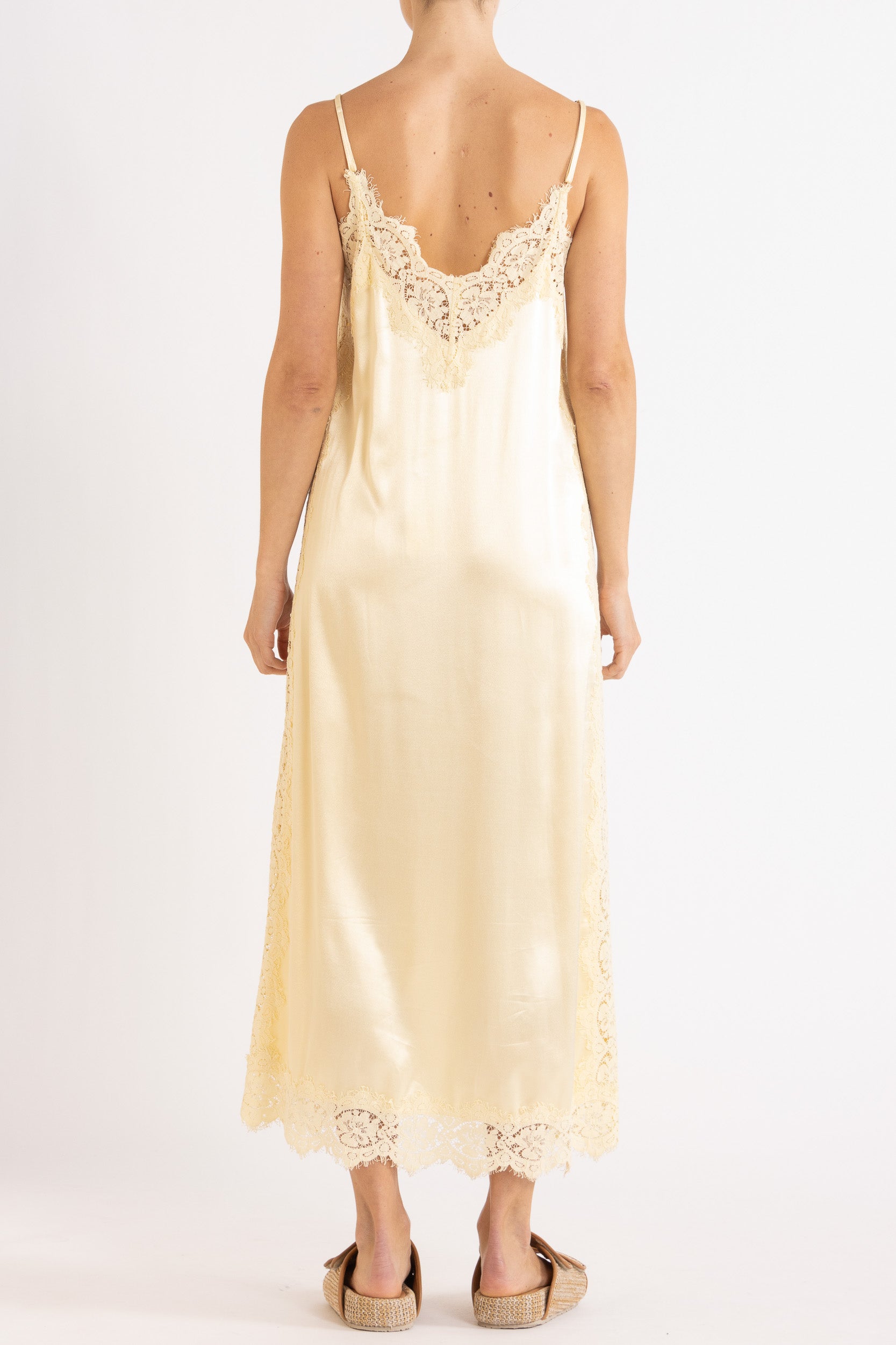 Woman wearing vanilla  lace-trimmed camisole slip dress