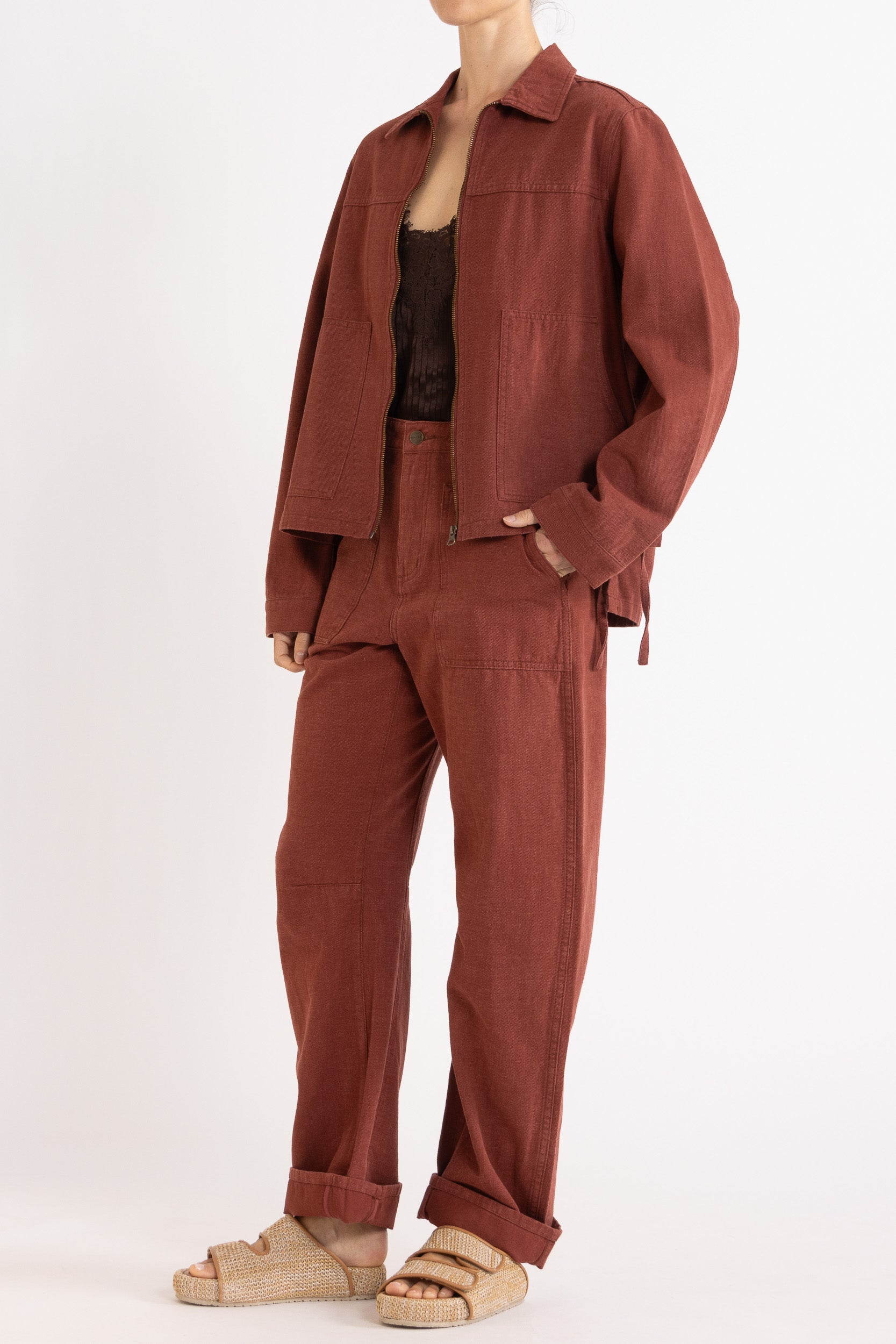 Model wearing burgundy cotton-twill utility jacket, chocolate satin cami with lace trims & burgundy cotton-twill pant, front-side view